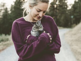 אישה מחזיקה גור חתולים