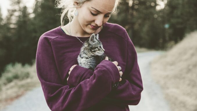 אישה מחזיקה גור חתולים